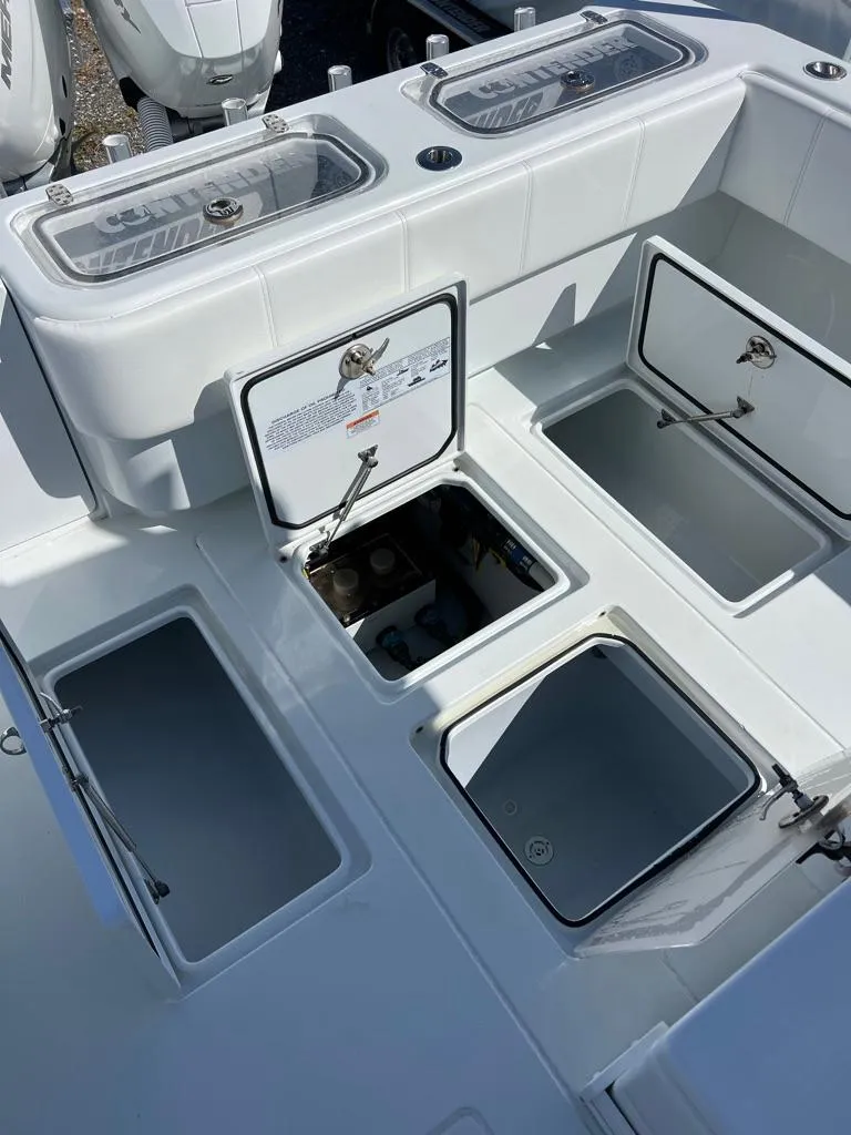 Slide: The Image of 2024 Contender 35 ST boat deck with open storage compartments and livewells. - 11