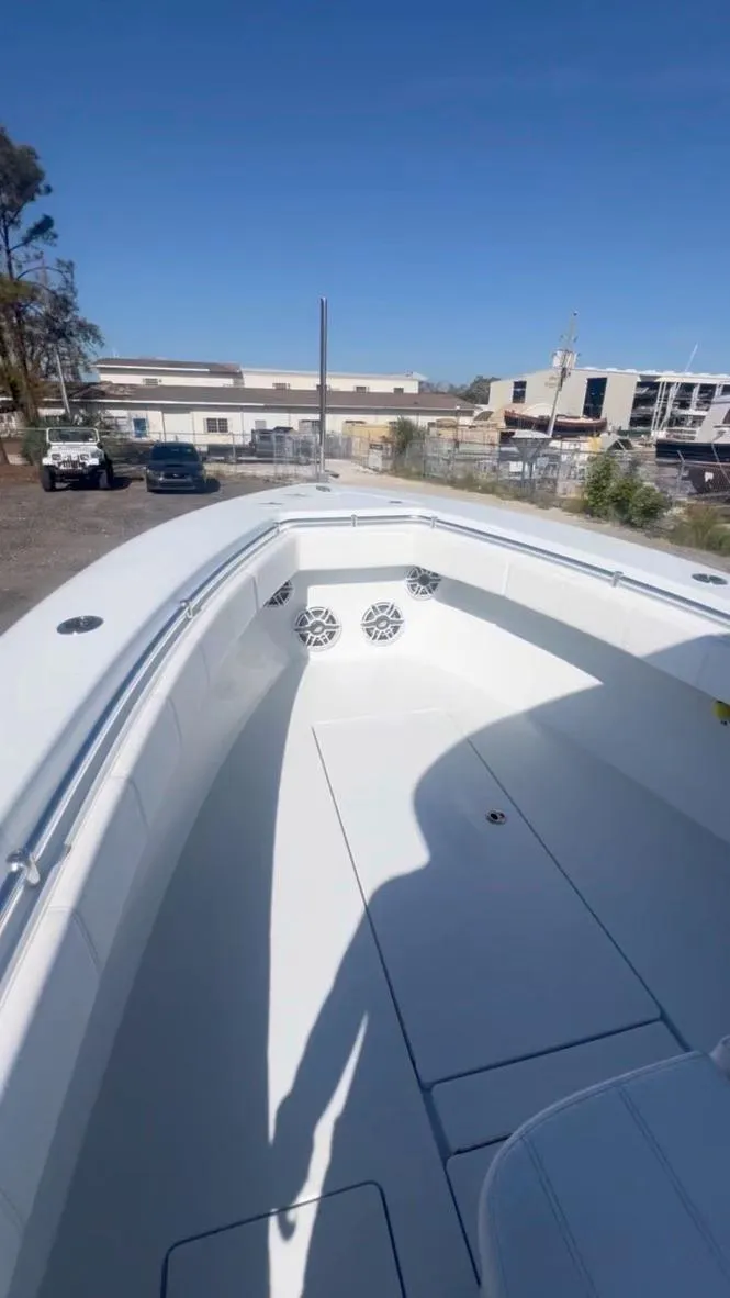 Slide: The Image of 2024 Contender 35 ST boat, spacious deck, docked outdoors under clear blue sky. - 12