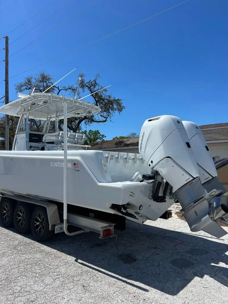 Slide: The Image of 2024 Contender 35 ST boat on trailer with dual outboard engines, parked outdoors. - 2