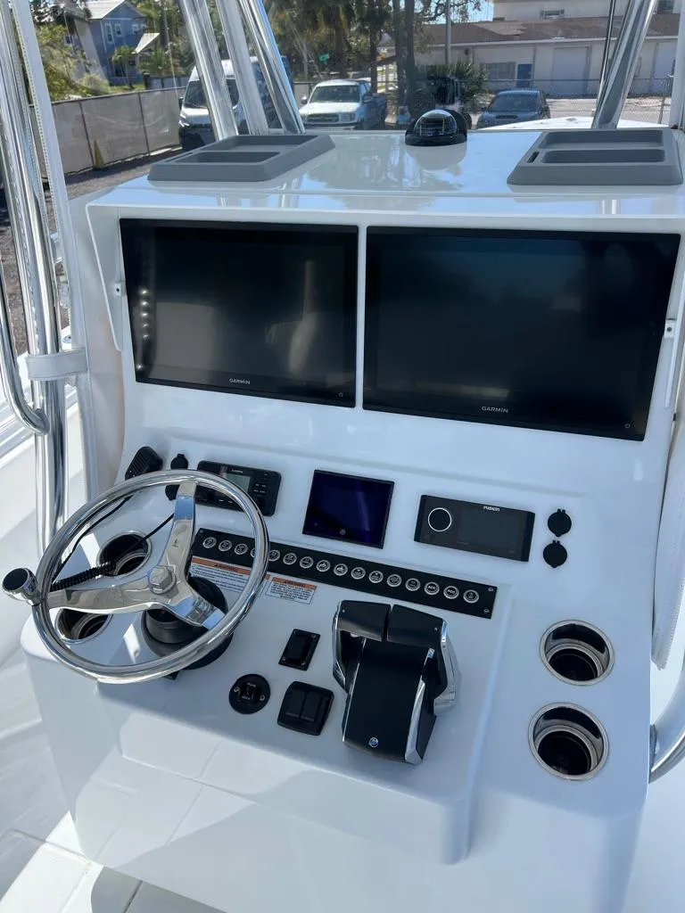 Slide: The Image of 2024 Contender 35 ST boat dashboard with dual screens and steering wheel. - 6