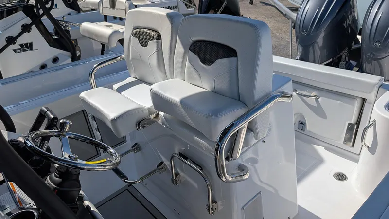 Slide: The Image of 2025 Wellcraft 243 Fisherman boat interior with dual helm seats and steering wheel. - 14