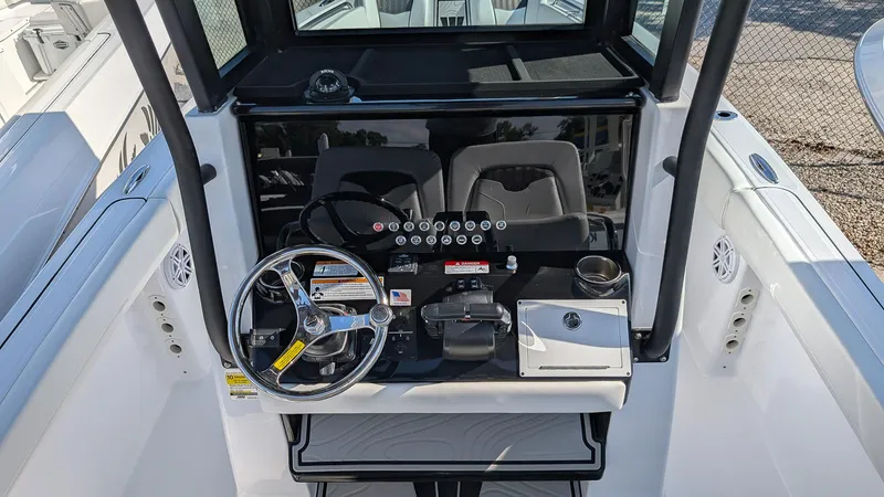 Slide: The Image of 2025 Wellcraft 243 Fisherman boat cockpit with steering wheel and controls. - 15