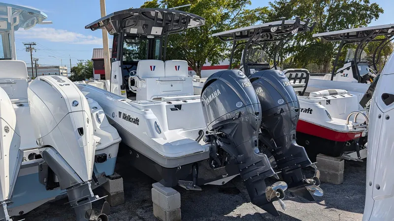 Slide: The Image of 2025 Wellcraft 243 Fisherman boat with dual outboard engines, displayed outdoors. - 2