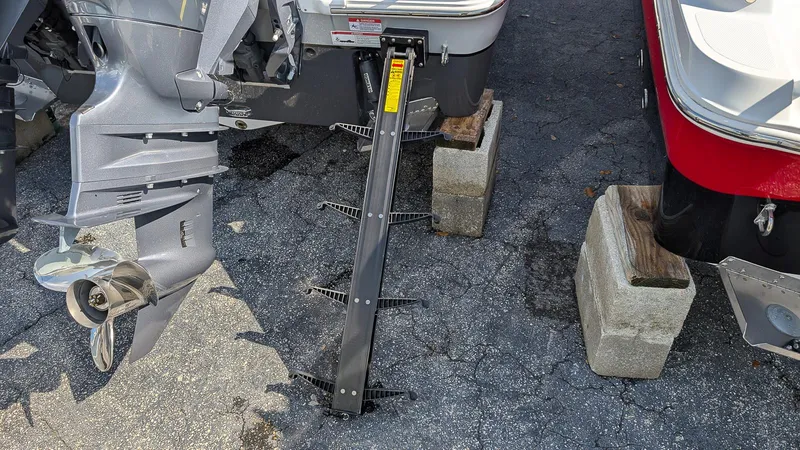 Slide: The Image of 2025 Wellcraft 243 Fisherman boat on blocks, showing outboard motor and support stand. - 5