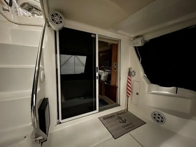 Slide: The Image of 2005 Sea Ray 420 Sedan Bridge interior with sliding door and welcome mat. - 13