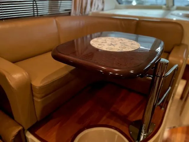Slide: The Image of Interior of 2005 Sea Ray 420 Sedan Bridge with leather seating and wooden table. - 20