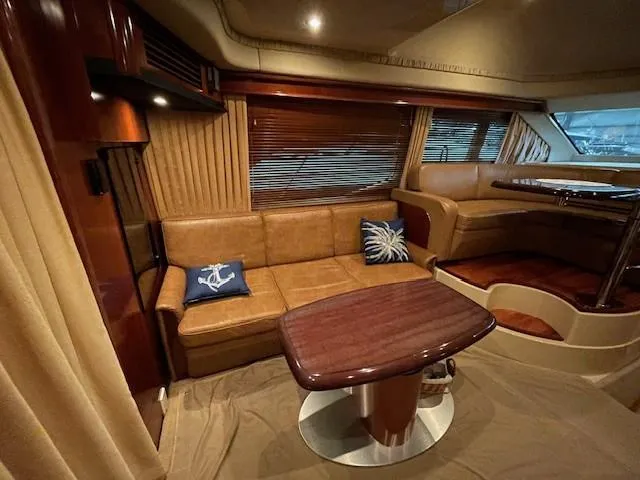 Slide: The Image of Luxurious interior of 2005 Sea Ray 420 Sedan Bridge with leather seating and wooden table. - 26