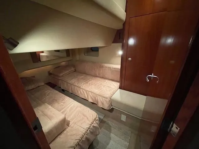 Slide: The Image of 2005 Sea Ray 420 Sedan Bridge cabin with twin beds and wooden cabinetry. - 33