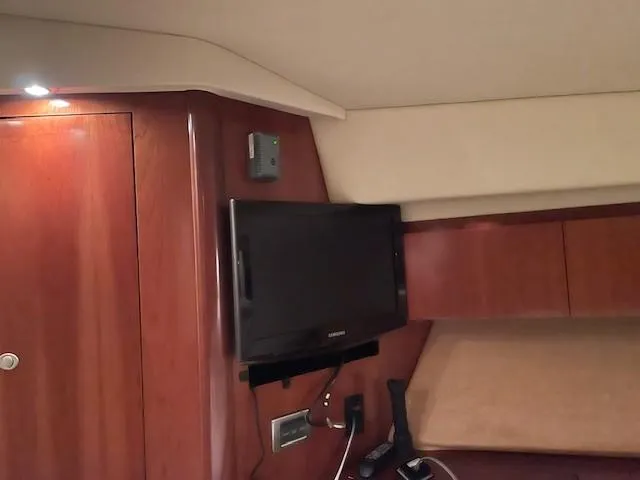 Slide: The Image of Interior of 2005 Sea Ray 420 Sedan Bridge with mounted TV and wooden cabinetry. - 37