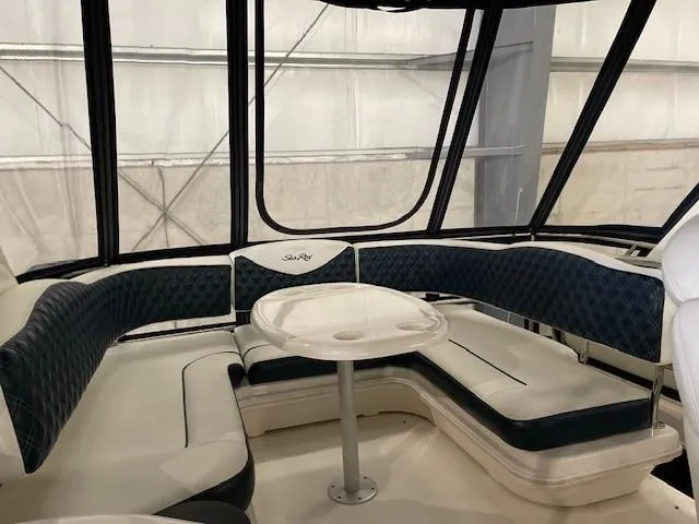Slide: The Image of 2005 Sea Ray 420 Sedan Bridge interior with cushioned seating and table. - 4