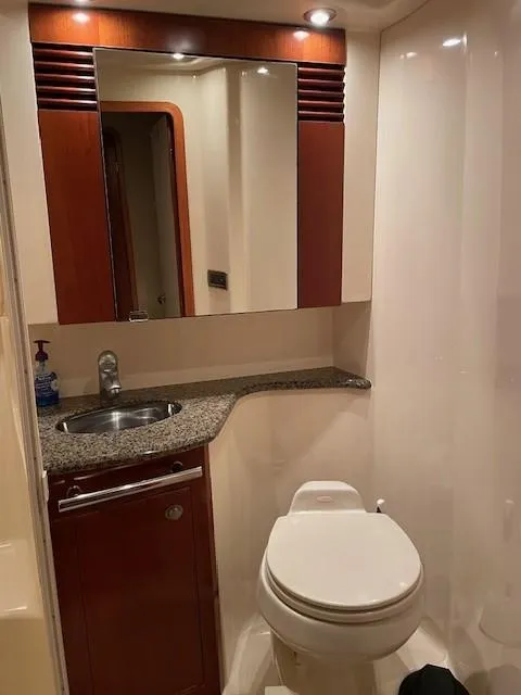 Slide: The Image of 2005 Sea Ray 420 Sedan Bridge bathroom with sink, mirror, and toilet. - 41