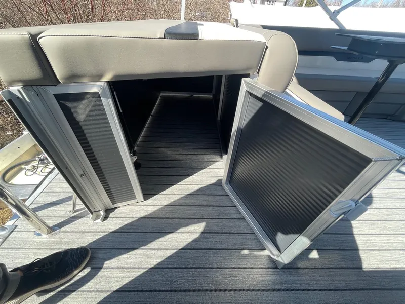 Slide: The Image of 2025 Armada Saphir 23CR boat storage compartment with open doors on striped deck. - 14