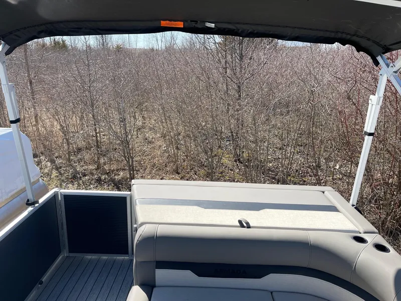 Slide: The Image of 2025 Armada Saphir 23CR boat interior with seating, surrounded by bare trees. - 15