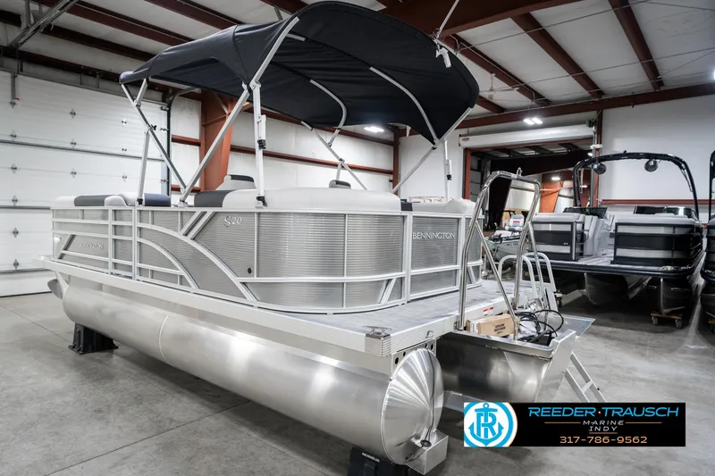 Slide: The Image of 2025 Bennington 20 SSR pontoon boat in showroom, featuring sleek design and canopy. - 10