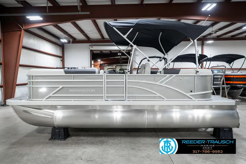 Slide: The Image of 2025 Bennington 20 SSR pontoon boat in showroom with black canopy. - 11