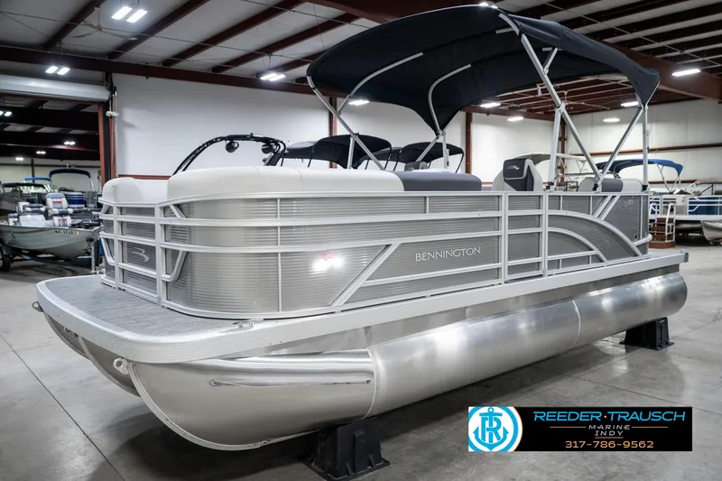 Slide: The Image of 2025 Bennington 20 SSR pontoon boat in showroom, featuring sleek design and canopy. - 3