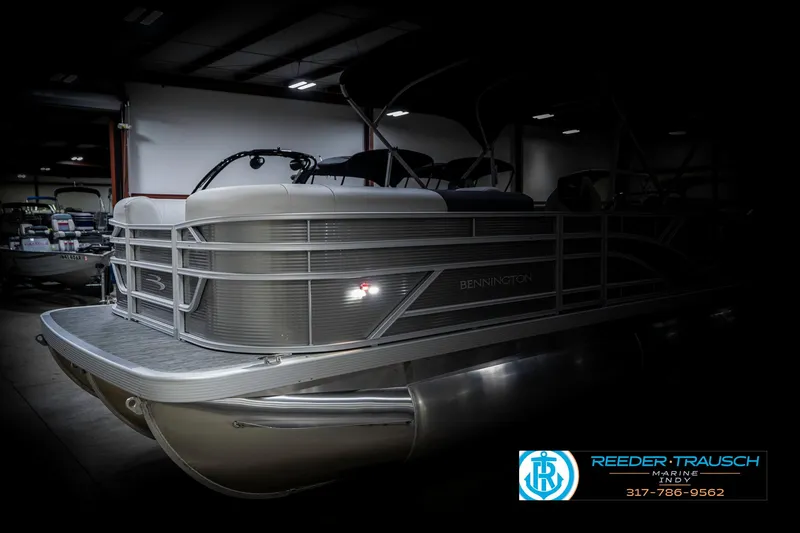 Slide: The Image of 2025 Bennington 20 SSR pontoon boat in showroom, side view, low lighting. - 4