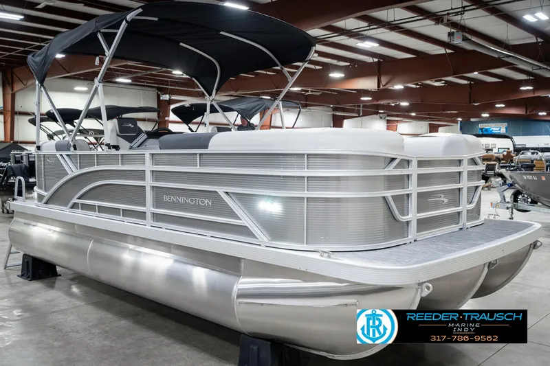 Slide: The Image of 2025 Bennington 20 SSR pontoon boat in showroom with canopy and sleek design. - 6