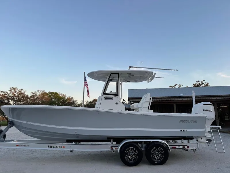 Slide: The Image of 2020 Regulator 26XO boat on trailer, side view with American flag in background. - 1
