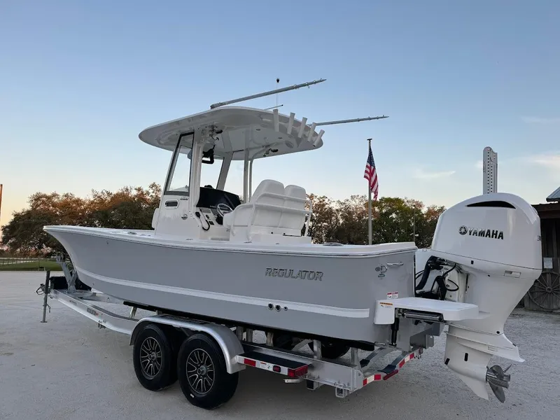 Slide: The Image of 2020 Regulator 26XO boat on trailer with Yamaha engine, parked outdoors. - 14