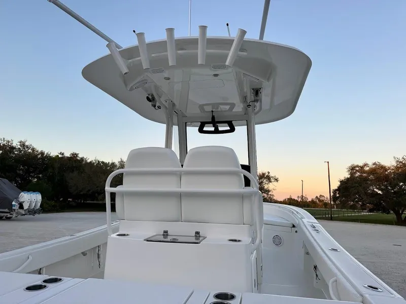 Slide: The Image of 2020 Regulator 26XO boat interior with seating and rod holders at sunset. - 19