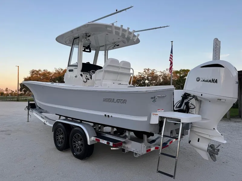 Slide: The Image of 2020 Regulator 26XO boat on trailer with Yamaha engine, parked outdoors. - 2