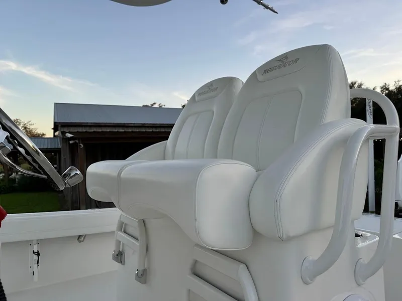 Slide: The Image of 2020 Regulator 26XO boat with white cushioned seats and steering wheel. - 23