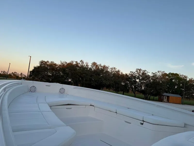 Slide: The Image of 2020 Regulator 26XO boat interior with white seating under a clear sky. - 24