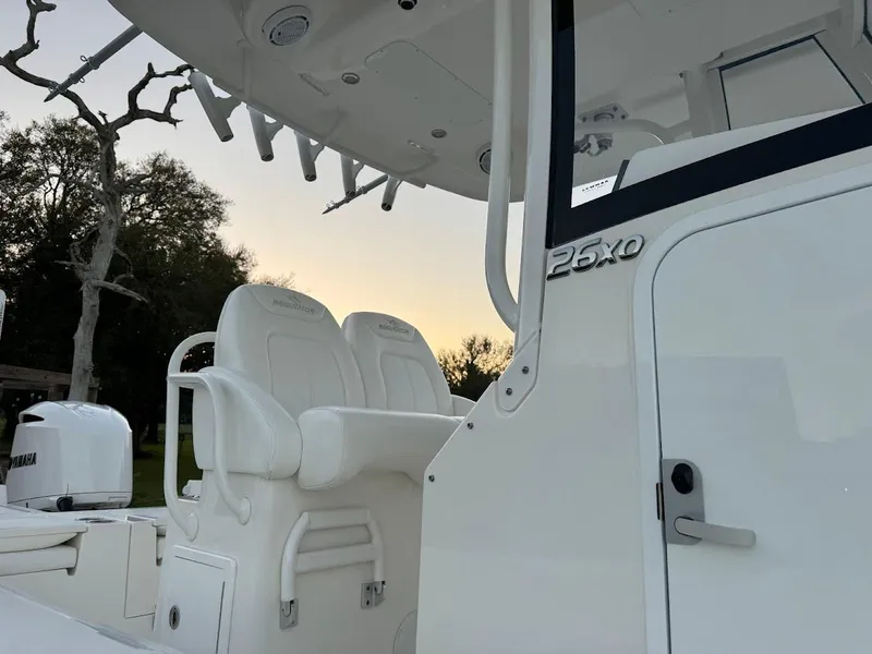 Slide: The Image of 2020 Regulator 26XO boat interior with seating and helm, at sunset. - 30