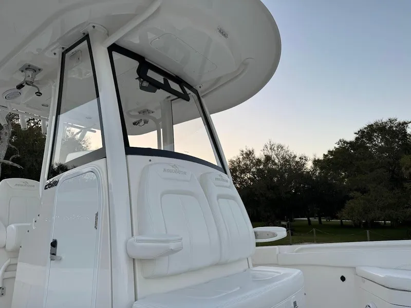 Slide: The Image of 2020 Regulator 26XO boat console with seating, against a serene outdoor backdrop. - 33