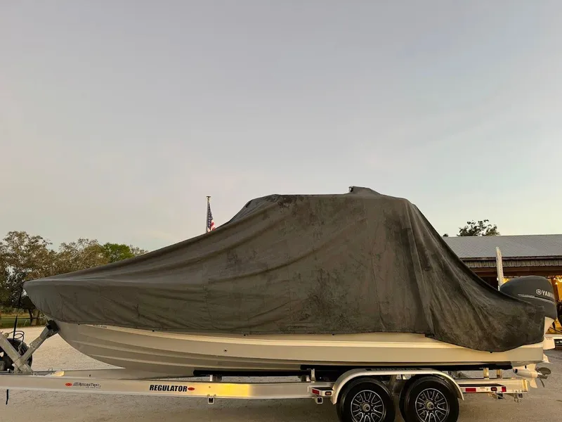 Slide: The Image of 2020 Regulator 26XO boat covered on trailer, parked outdoors. - 40