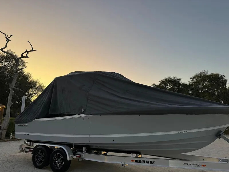 Slide: The Image of 2020 Regulator 26XO boat covered on trailer at sunset. - 42