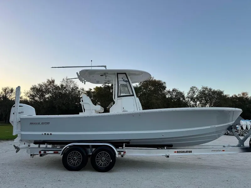 Slide: The Image of 2020 Regulator 26XO boat on trailer, side view, outdoors at dusk. - 6