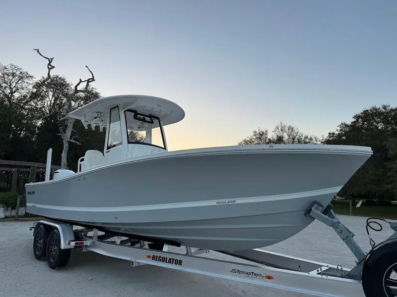 Slide: The Image of 2020 Regulator 26XO boat on trailer, parked outdoors at sunset. - 7