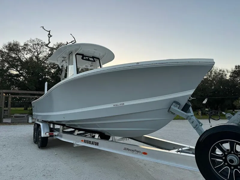Slide: The Image of 2020 Regulator 26XO boat on trailer, parked outdoors, side view. - 8