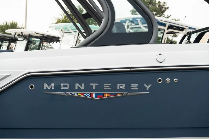 Slide: The Image of 2025 Monterey Elite 27 OB boat side view with logo and emblem. - 11
