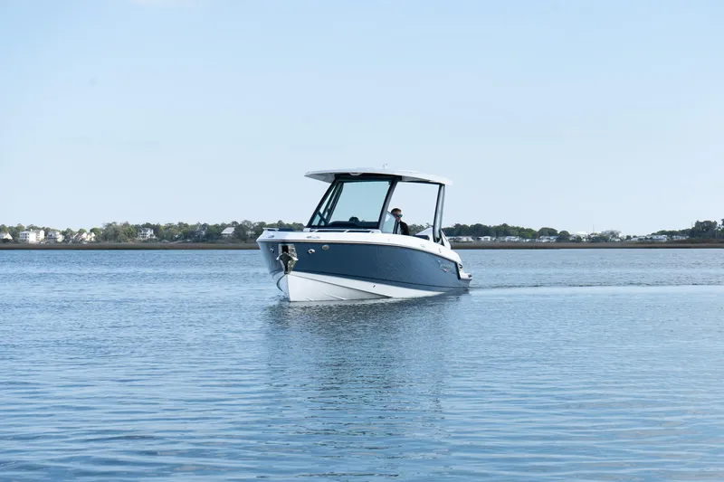 Slide: The Image of 2025 Monterey Elite 27 OB boat cruising on calm water under clear sky. - 34