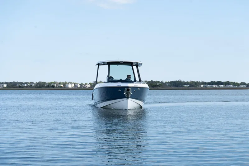 Slide: The Image of 2025 Monterey Elite 27 OB boat cruising on calm water under a clear sky. - 35