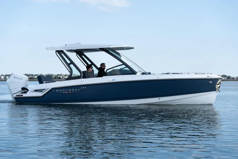 Slide: The Image of 2025 Monterey Elite 27 OB boat cruising on calm water under a clear sky. - 38