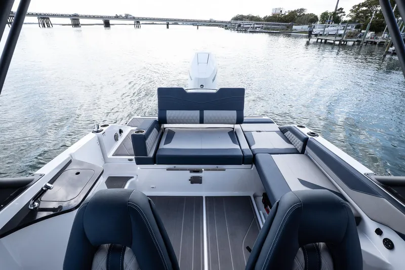 Slide: The Image of 2025 Monterey Elite 27 OB boat interior with seating, overlooking calm waters and distant bridge. - 43