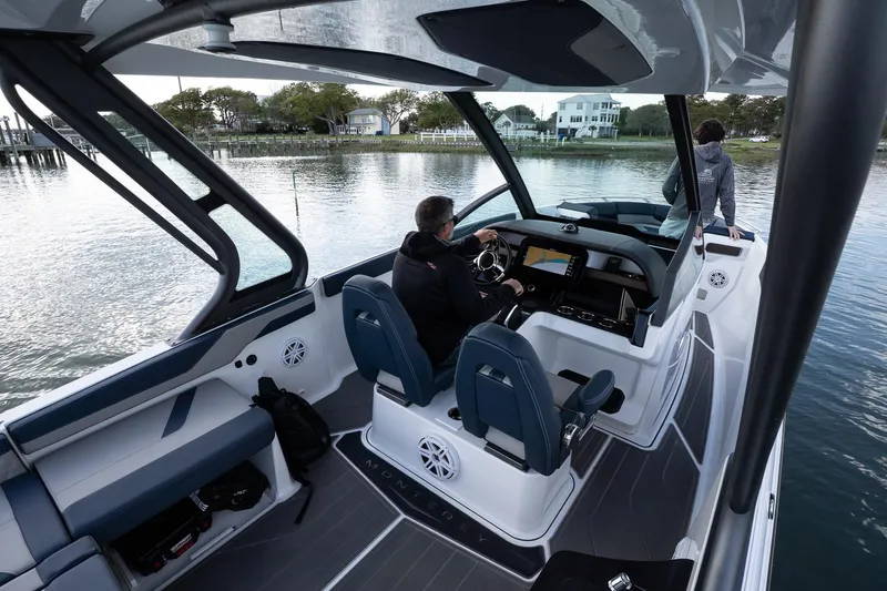 Slide: The Image of 2025 Monterey Elite 27 OB boat interior with two people on a calm lake. - 46