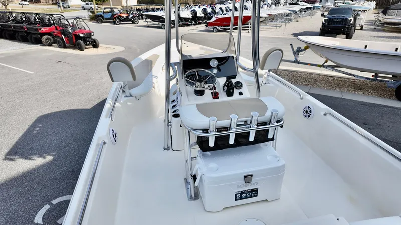 Slide: The Image of 2026 Bulls Bay 2200 XS boat interior with console and seating, parked in a marina. - 14