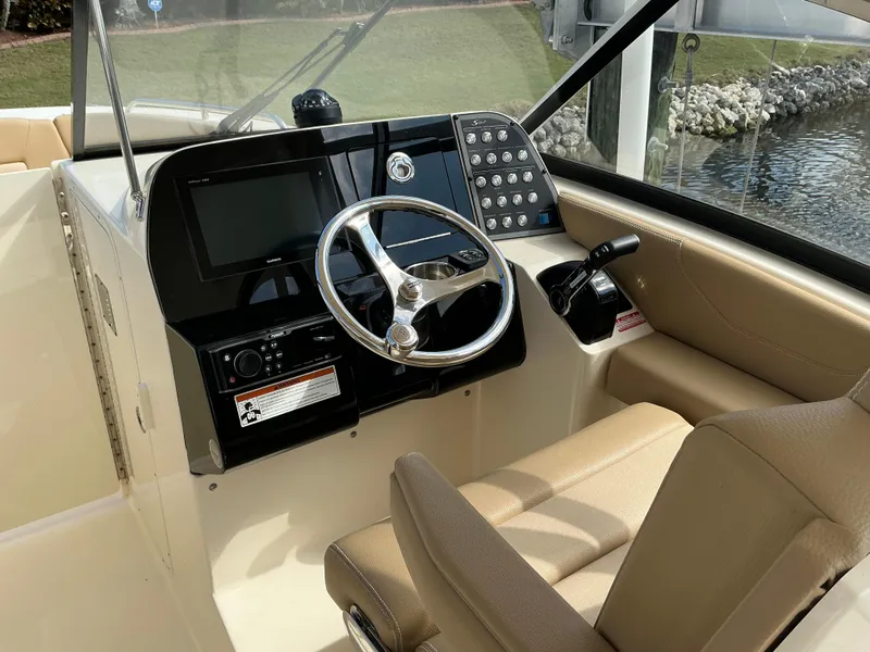 Slide: The Image of 2019 Scout 255 Dorado boat interior with beige seating and built-in speakers. - 10