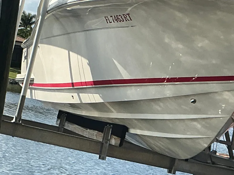 Slide: The Image of 2019 Scout 255 Dorado boat on lift, docked by waterfront homes. - 3