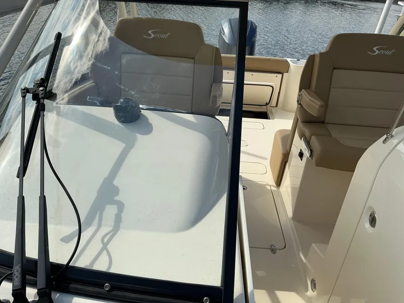 Slide: The Image of 2019 Scout 255 Dorado boat anchor compartment with open hatch, near rocky shoreline. - 7
