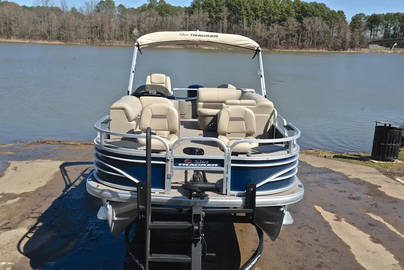 Slide: The Image of 2023 Sun Tracker Fishin Barge 20 DLX pontoon boat docked by a serene lake. - 17