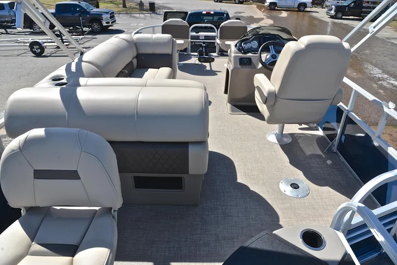 Slide: The Image of 2023 Sun Tracker Fishin Barge 20 DLX interior with beige seating and steering console. - 18