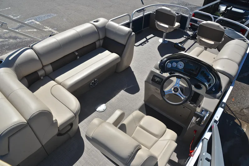 Slide: The Image of 2023 Sun Tracker Fishin Barge 20 DLX interior with beige seating and steering console. - 19