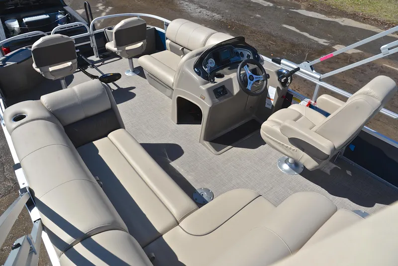 Slide: The Image of 2023 Sun Tracker Fishin Barge 20 DLX interior with beige seating and steering console. - 23