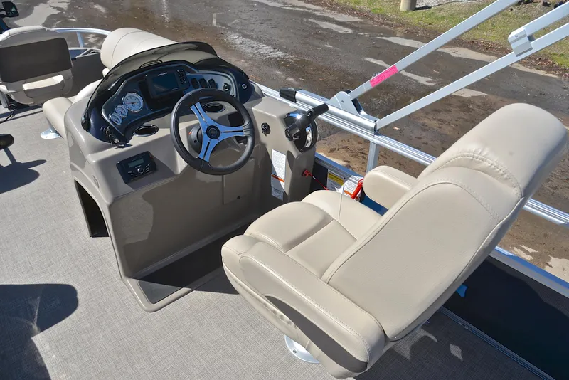 Slide: The Image of 2023 Sun Tracker Fishin Barge 20 DLX interior with steering console and beige seating. - 25